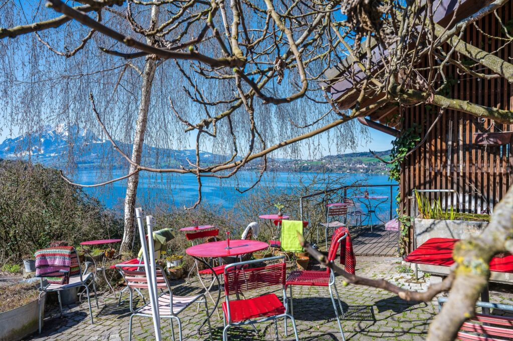 Hofcafe Gartensitzplatz mit Blick auf den See und die Berge im Hintergrund